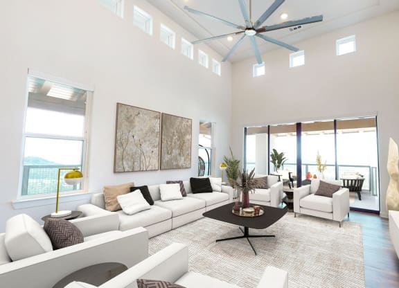 a living room with white furniture and a ceiling fan