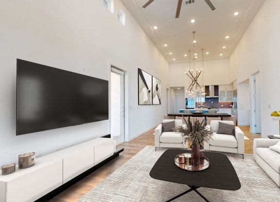 a living room with white furniture and a tv on the wall