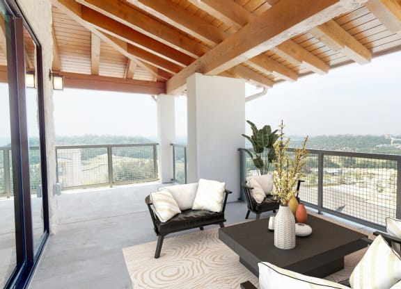 a living room with a table and chairs on a balcony