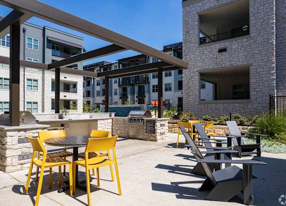 a patio with tables and chairs and a grill at the axis at princeton yards