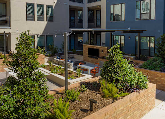 a courtyard with benches and trees in front of a building