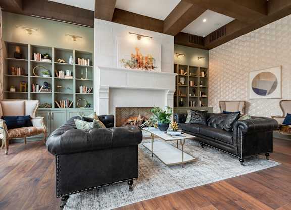 a living room with two leather couches and a fireplace