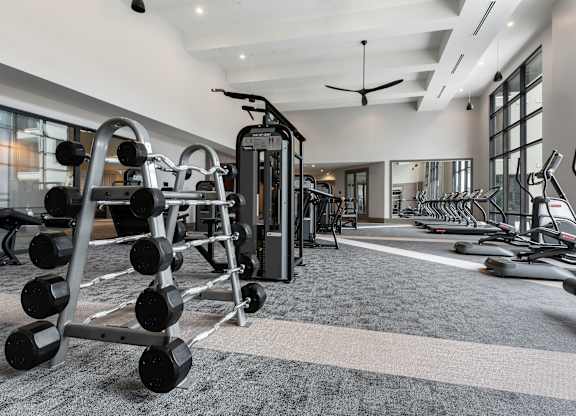 a gym with weights and other exercise equipment on a carpeted floor