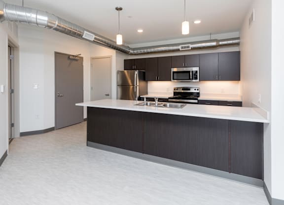 Modern open-concept kitchen and living area with stainless steel appliances.