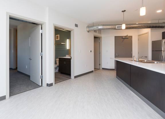 Modern open-concept kitchen and living area with stainless steel appliances.