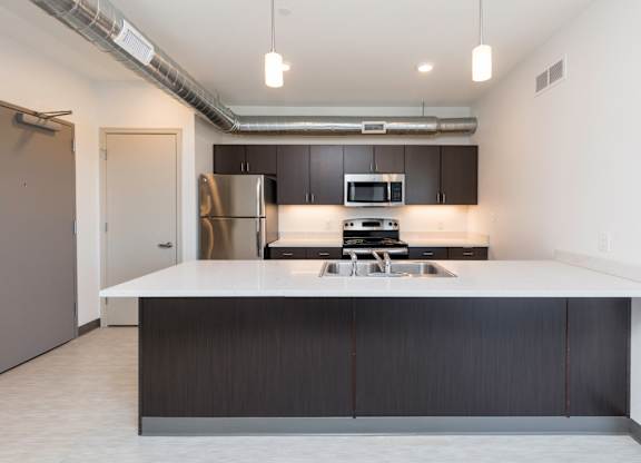 Modern open-concept kitchen and living area with stainless steel appliances.
