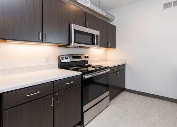 Modern open-concept kitchen and living area with stainless steel appliances.