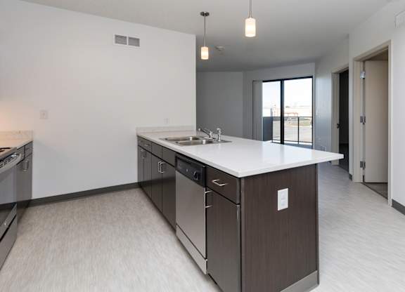 Modern open-concept kitchen and living area with stainless steel appliances.