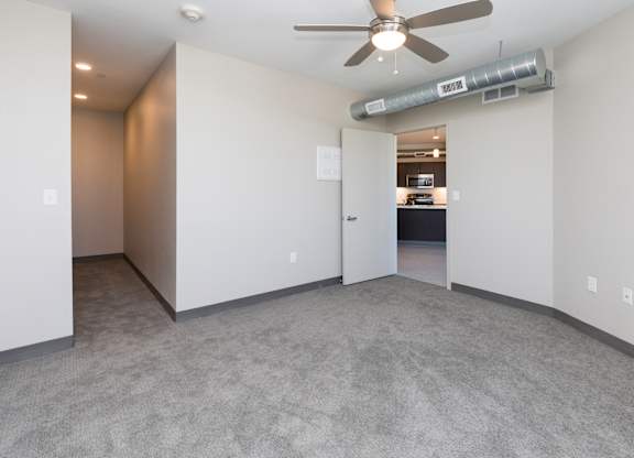 Bright, vacant bedroom with neutral walls and carpet flooring.