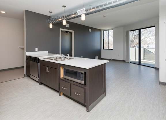 Modern open-concept kitchen and living area with stainless steel appliances.