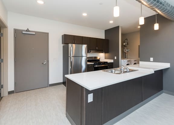 Modern open-concept kitchen and living area with stainless steel appliances.