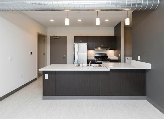 Modern open-concept kitchen and living area with stainless steel appliances.