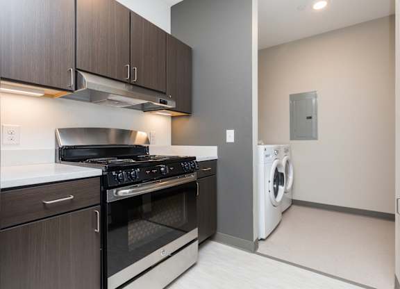 Modern open-concept kitchen and living area with stainless steel appliances.