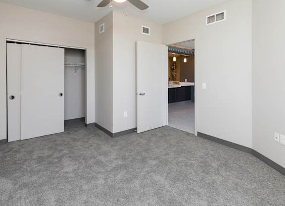 Bright, vacant bedroom with neutral walls and carpet flooring.