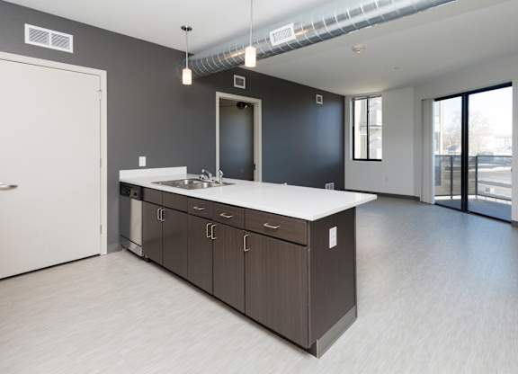 Modern open-concept kitchen and living area with stainless steel appliances.