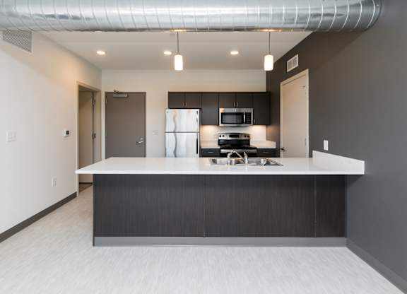 Modern open-concept kitchen and living area with stainless steel appliances.