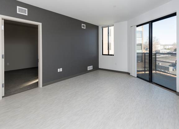 Modern open-concept kitchen and living area with stainless steel appliances.