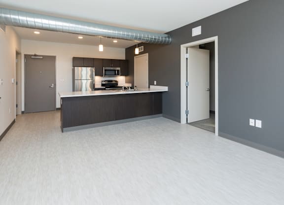 Modern open-concept kitchen and living area with stainless steel appliances.