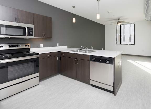 Modern open-concept kitchen and living area with stainless steel appliances.