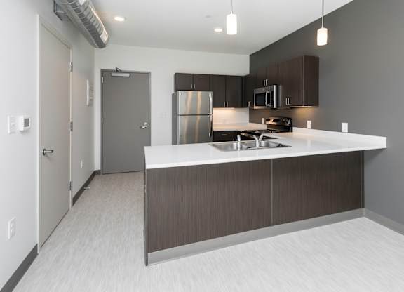 Modern open-concept kitchen and living area with stainless steel appliances.