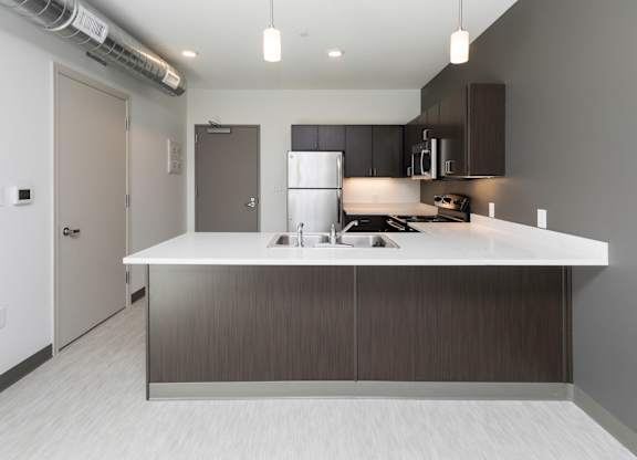 Modern open-concept kitchen and living area with stainless steel appliances.