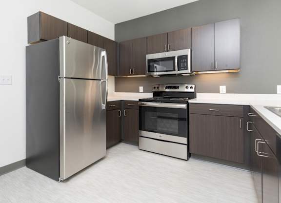 Modern open-concept kitchen and living area with stainless steel appliances.