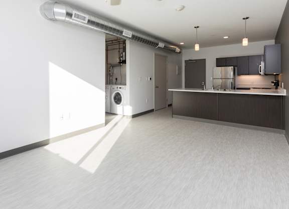 Modern open-concept kitchen and living area with stainless steel appliances.