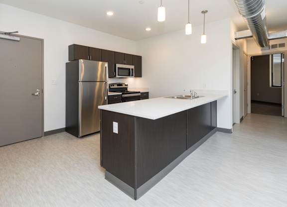 Modern open-concept kitchen and living area with stainless steel appliances.