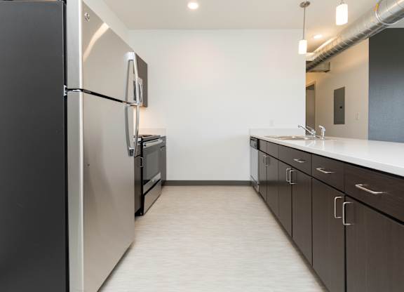 Modern open-concept kitchen and living area with stainless steel appliances.