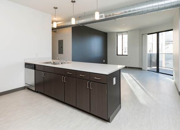 Modern open-concept kitchen and living area with stainless steel appliances.