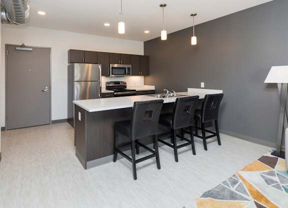 Modern open-concept kitchen and living area with stainless steel appliances.