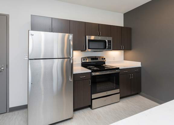 Modern open-concept kitchen and living area with stainless steel appliances.