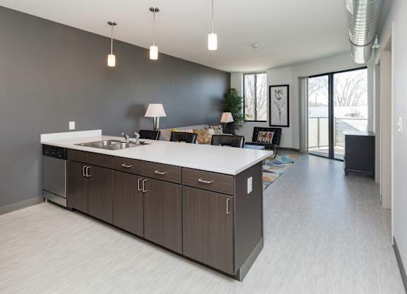 Modern open-concept kitchen and living area with stainless steel appliances.