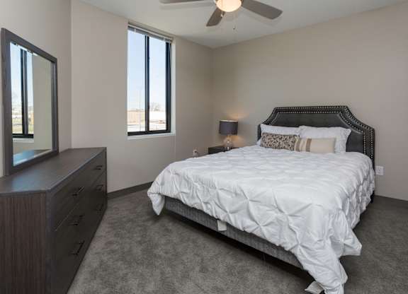 Bright, vacant bedroom with neutral walls and carpet flooring.