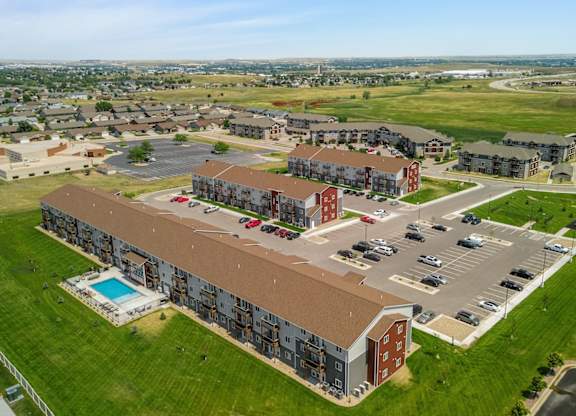 an aerial view of an apartment complex with cars parked in a parking lot