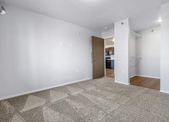 A room with a carpeted floor and a doorway leading to another room.
