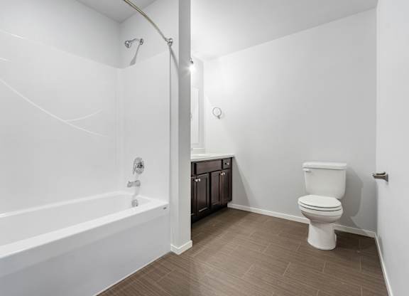 A white bathroom with a toilet and a bathtub.