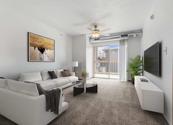 A living room with a white couch and a painting on the wall.