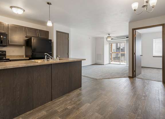 A kitchen with dark wood cabinets and a black stove top oven.