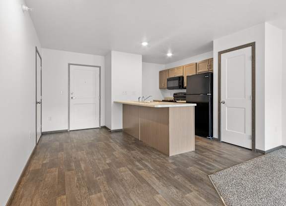 A kitchen with a refrigerator, microwave, and oven.