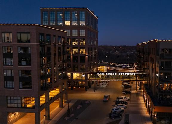 A view of a parking lot and buildings at night.