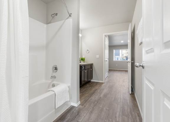A white bathroom with a white tub and a white door.