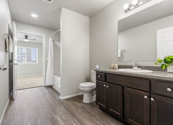 A bathroom with a toilet, sink, and a walk-in shower.