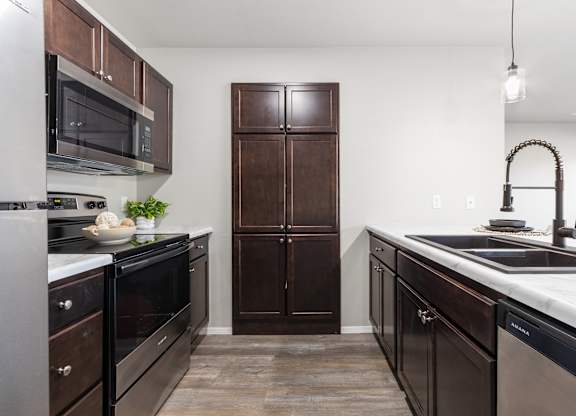 A kitchen with dark wood cabinets and stainless steel appliances.