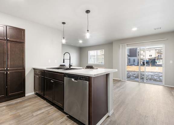A modern kitchen with a large island and wooden floors.