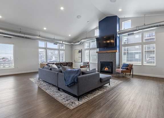 A modern living room with a grey sofa and a fireplace.