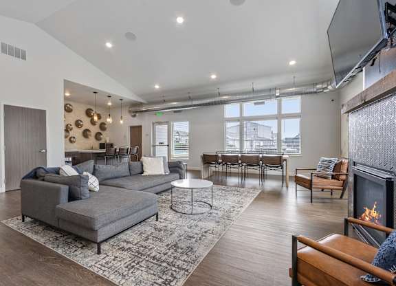 A modern living room with a grey sofa and a fireplace.