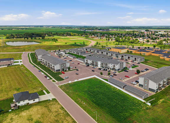 A large building complex with a parking lot in front.