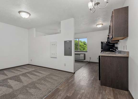 A room with a brown carpet and a wooden cabinet.