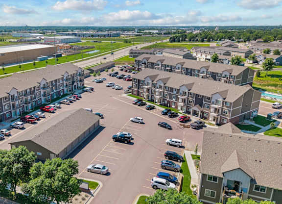 A large parking lot is surrounded by apartment buildings.